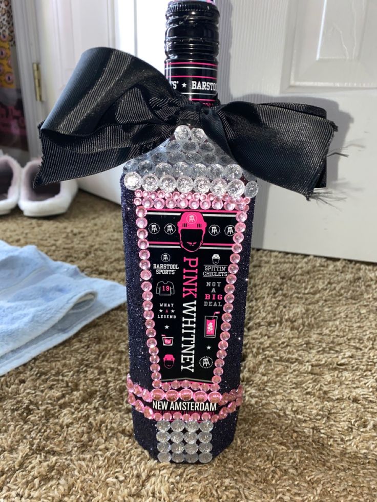 a bottle that is sitting on the floor with a bow around it's neck