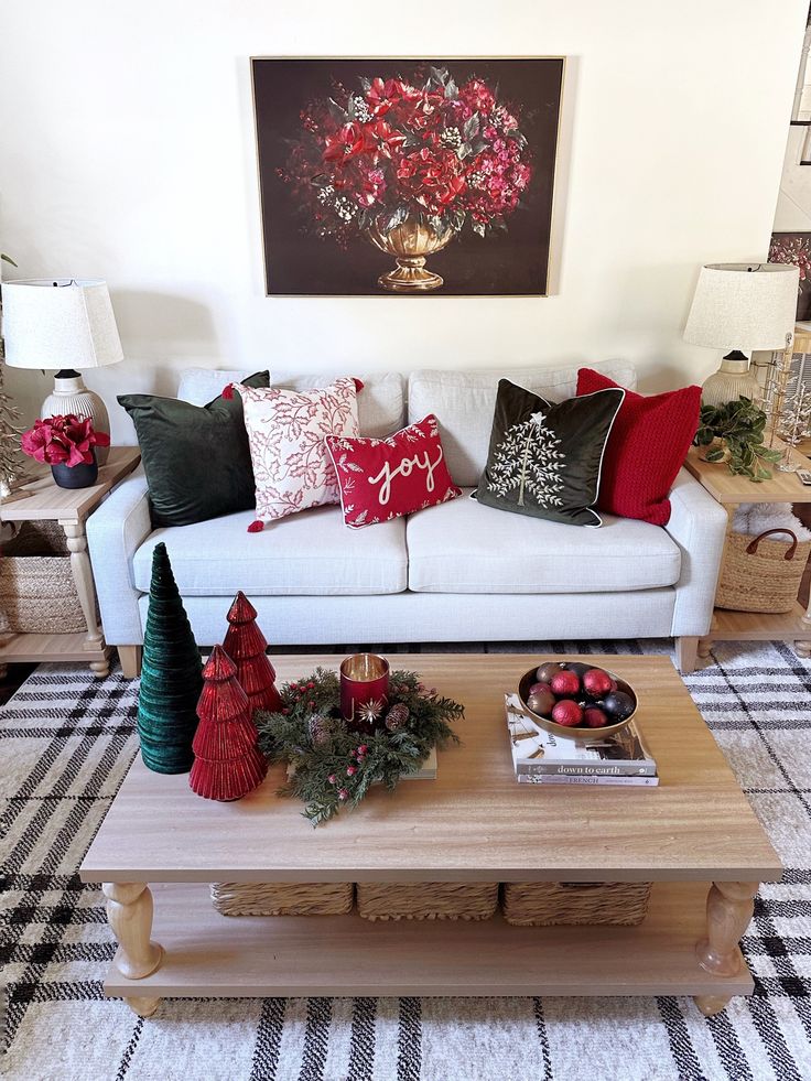 a living room filled with furniture and christmas decorations on top of a coffee table in front of a painting