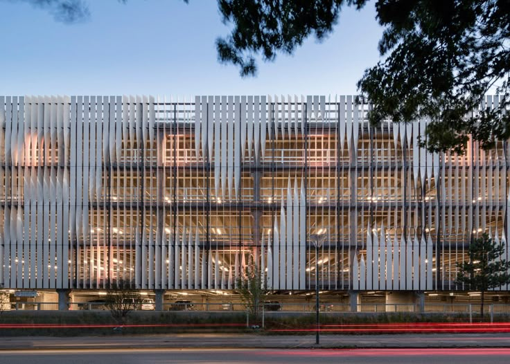 a large building that has many windows on the front and side of it at night