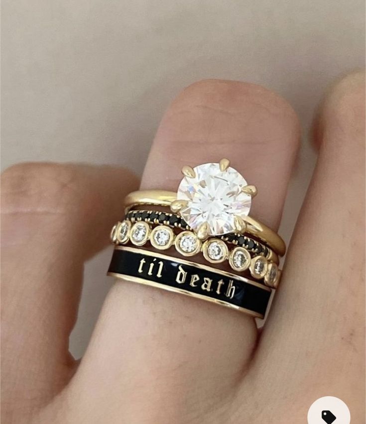 a woman's hand with two gold rings and a diamond ring on the finger