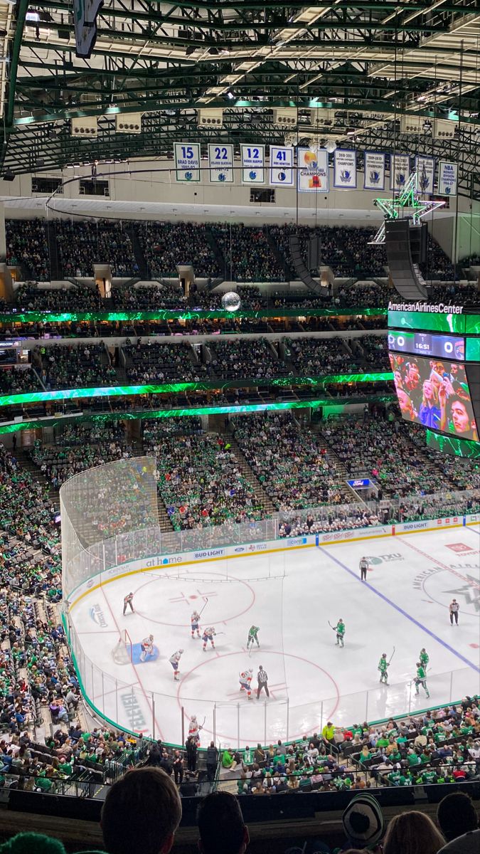 an ice hockey game is being played in a large arena