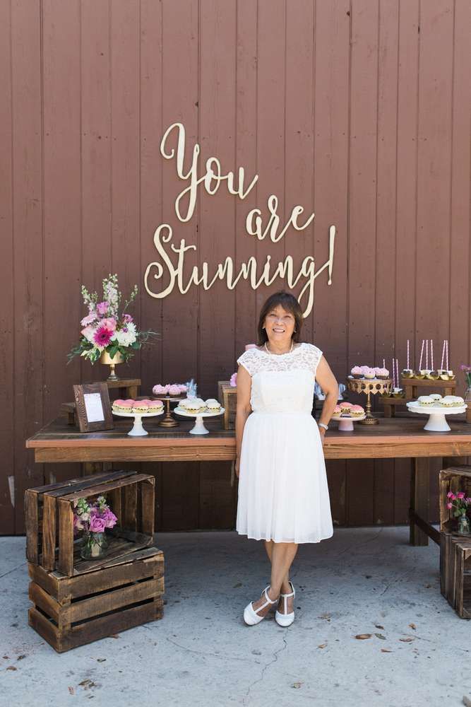 a woman standing in front of a table with cupcakes