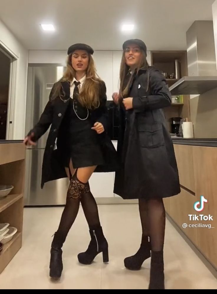 two women dressed in black are posing for the camera while standing next to each other