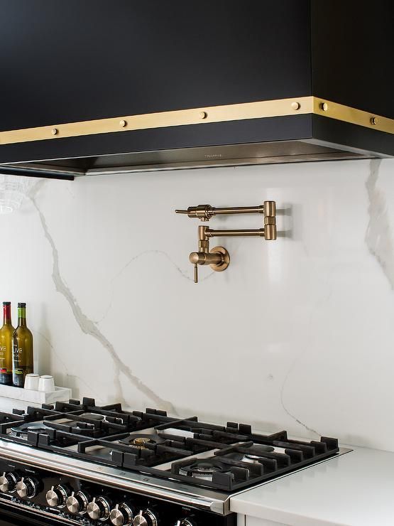 a stove top oven sitting inside of a kitchen next to a wall mounted range hood