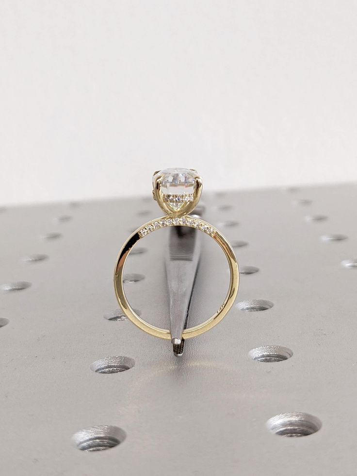 a diamond ring sitting on top of a piece of metal