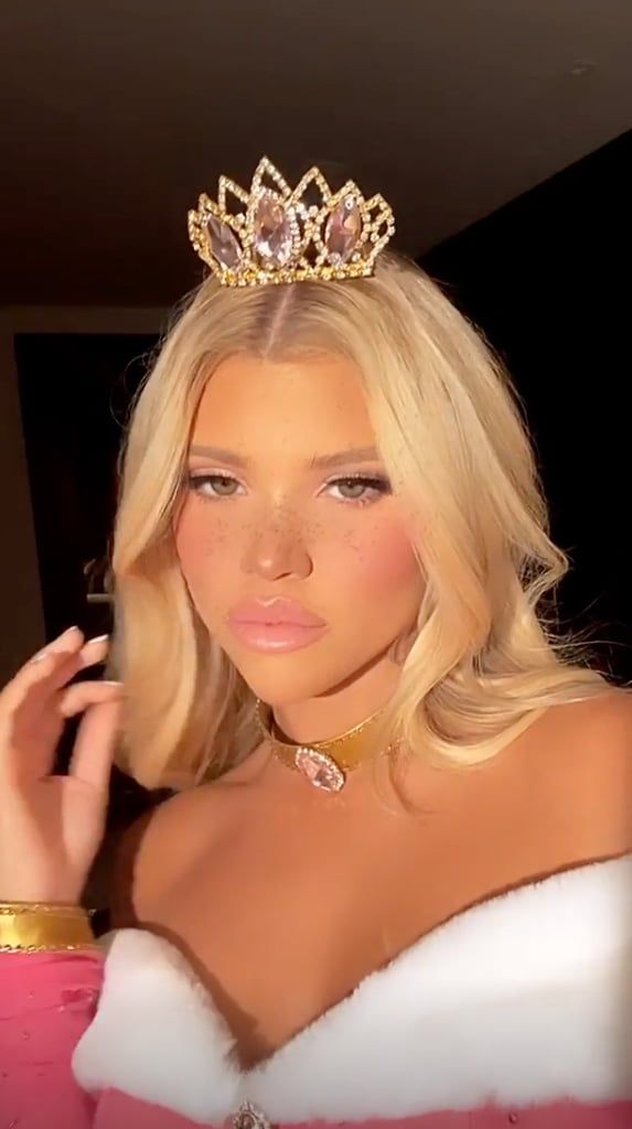 a blonde woman wearing a tiara and posing for the camera