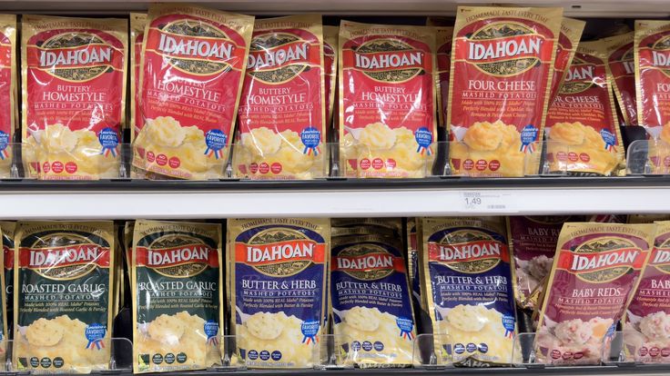 several packages of macaroni and cheese are on display in a grocery store shelf