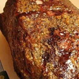 a large piece of meat sitting on top of a cutting board next to a knife