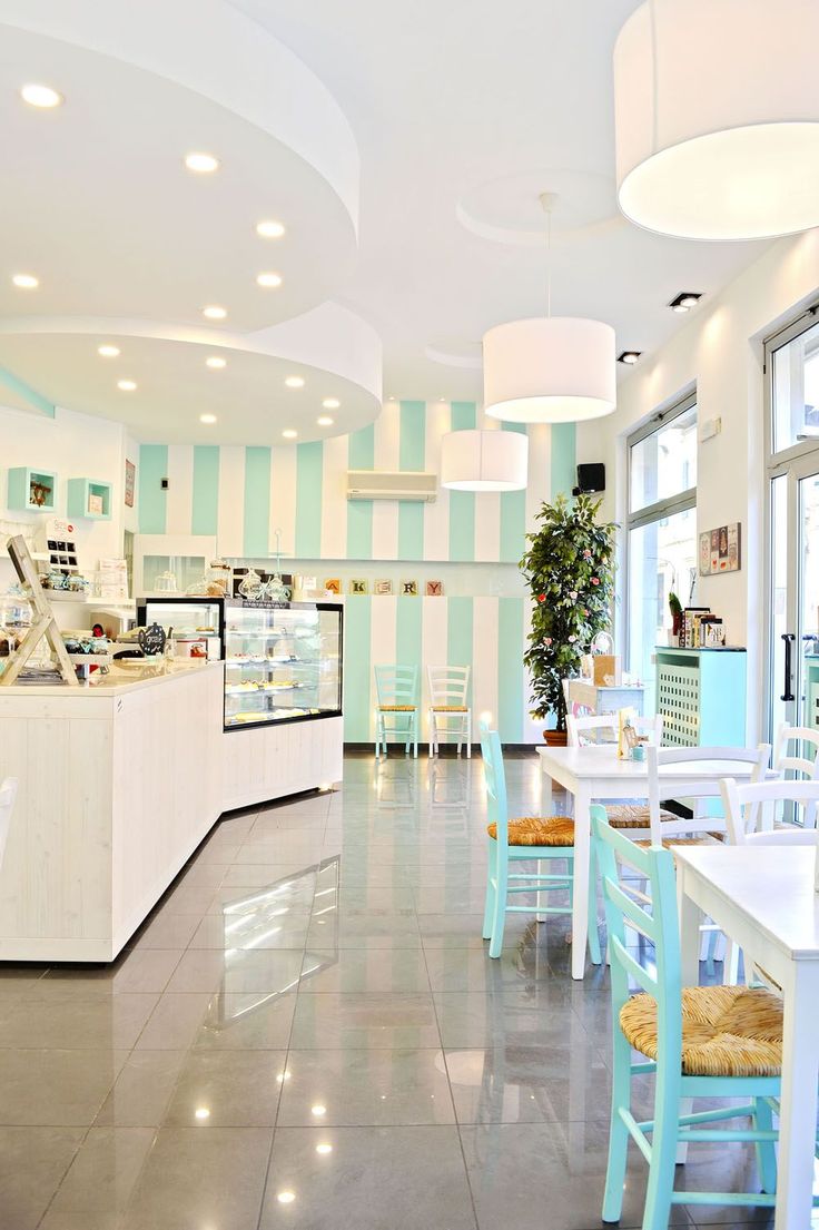 the interior of a restaurant with blue and white striped walls, large windows, and tables