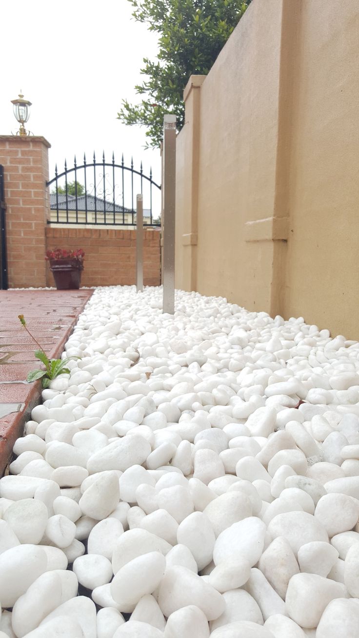 white rocks on the ground near a fence