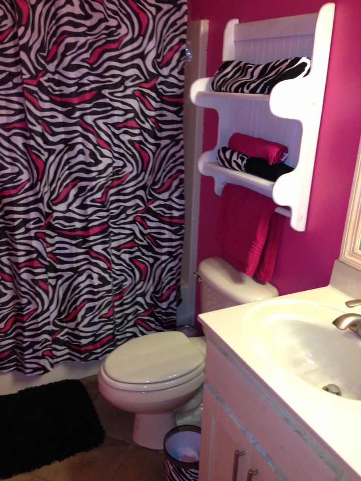 a bathroom with pink walls and zebra print shower curtain