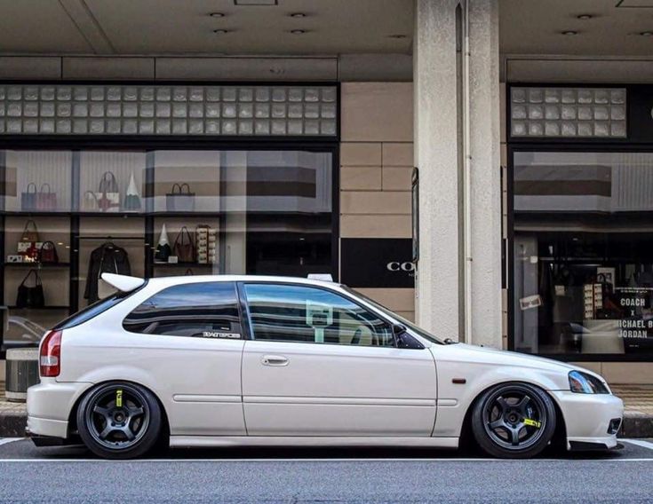 a white car parked in front of a building