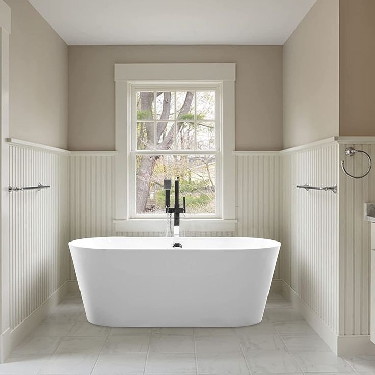 a white bath tub sitting under a window in a bathroom