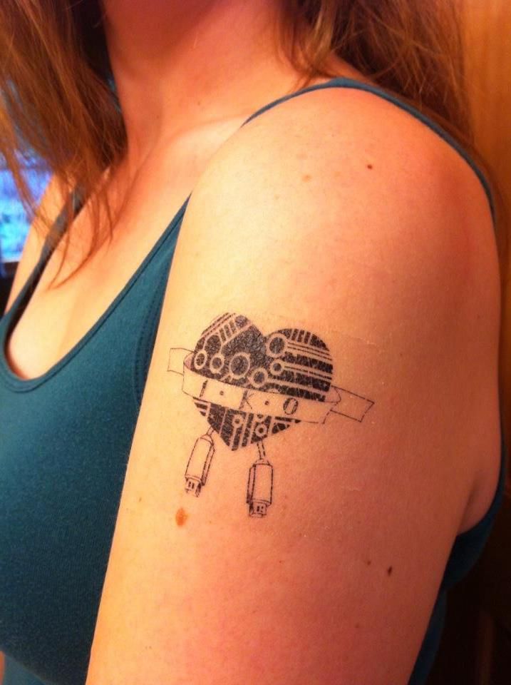 a woman with a tattoo on her arm that has a drawing of a plane in the shape of a heart