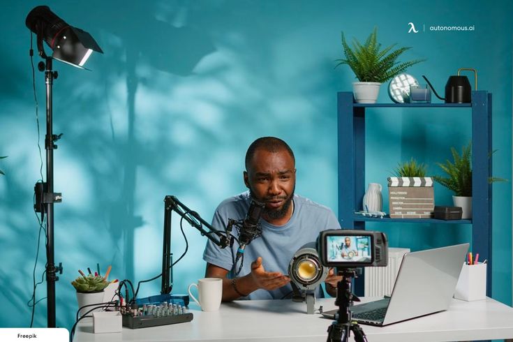 a man sitting at a desk with a camera in front of him