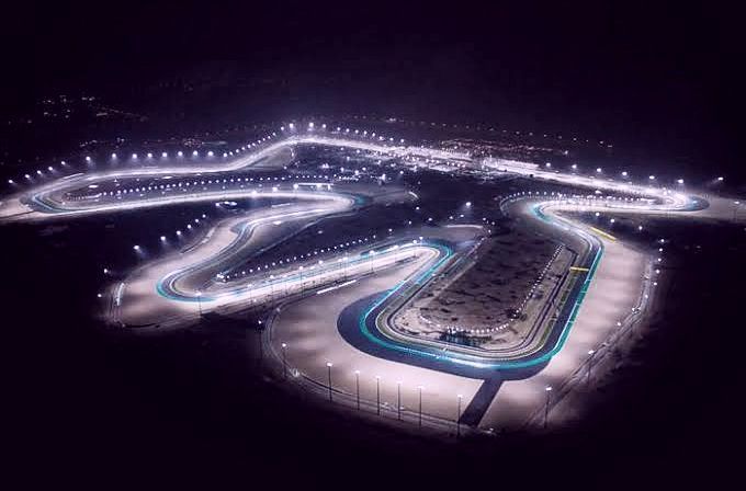 an aerial view of a race track at night, with lights on the top and bottom