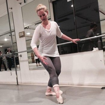 a woman in white shirt and grey pants doing ballet