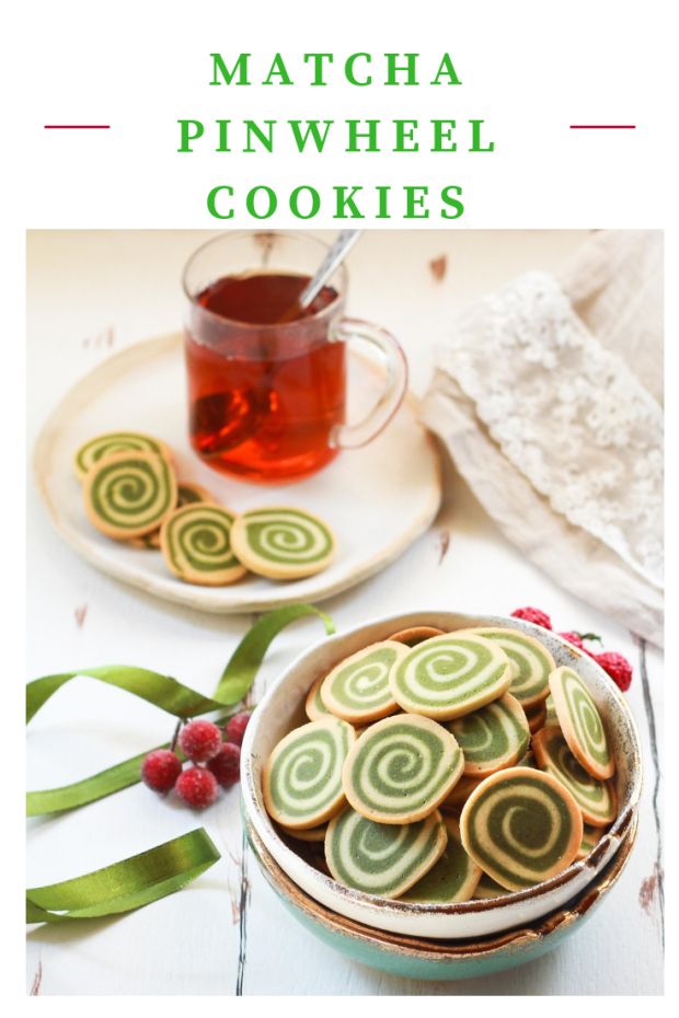 green and white cookies in a bowl next to a cup of tea on a plate