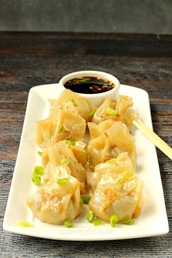 dumplings with dipping sauce on a white plate