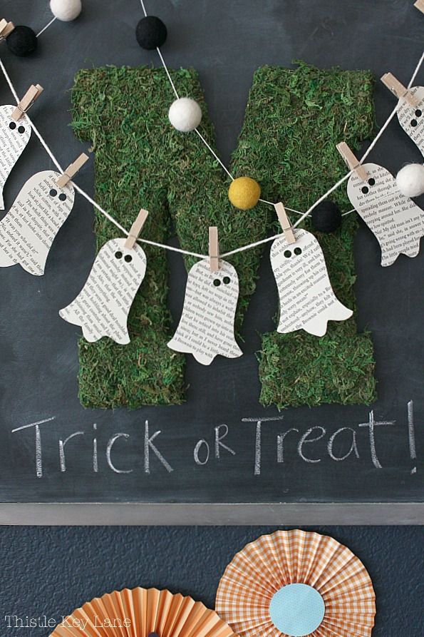 a chalk board with halloween decorations on it and the words trick or treat hanging from clothes pins