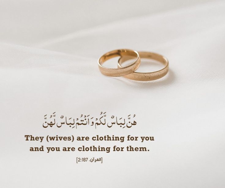 two gold wedding rings sitting on top of a white sheet with an arabic quote in the middle