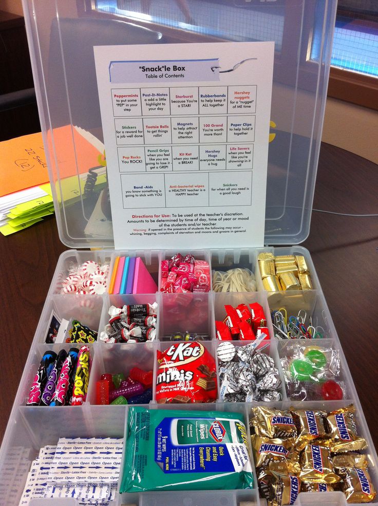 a clear plastic box filled with lots of candy and candies on top of a wooden table