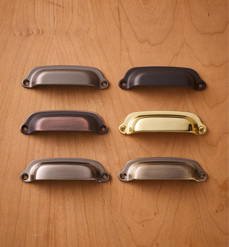 four different styles of door handles on a wooden surface