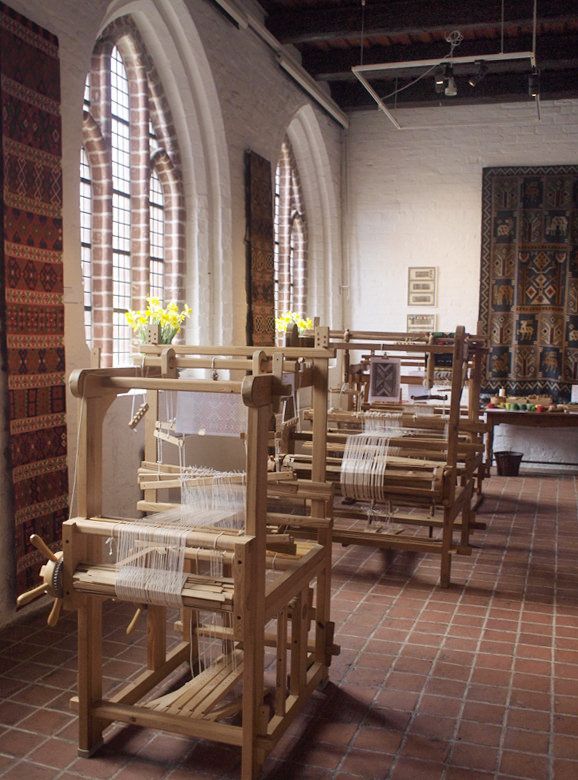 a row of wooden chairs sitting next to each other on top of a tiled floor