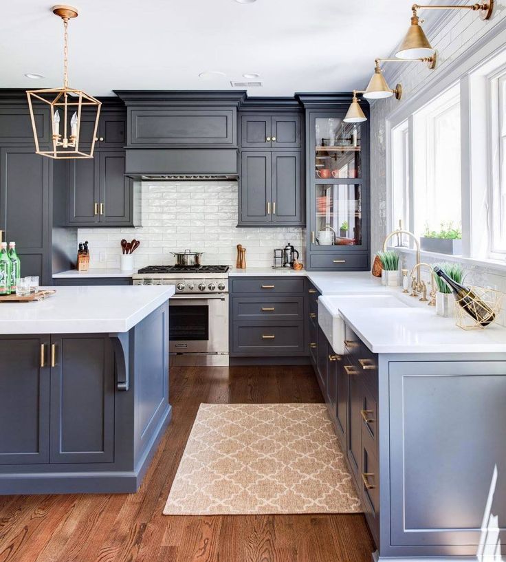 a kitchen with gray cabinets and white counter tops