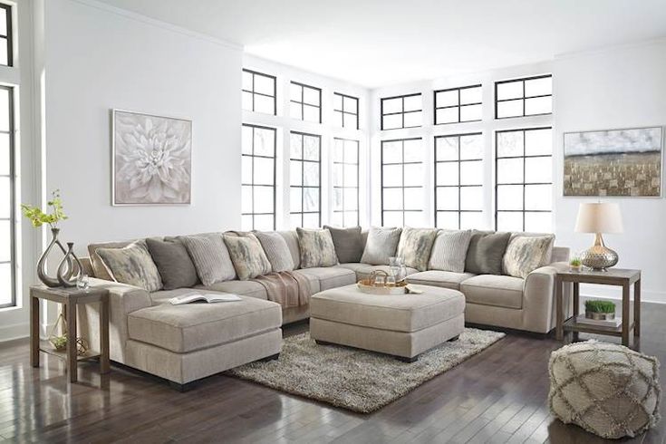 a living room filled with lots of furniture and decor on top of a hard wood floor