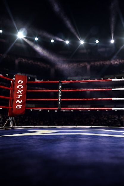 an empty boxing ring in the middle of a dark arena with bright lights on it