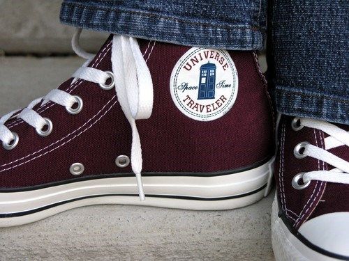 someone's feet wearing converse shoes with the doctor who logo on them and white laces