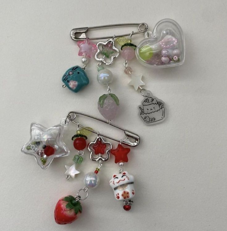 a bunch of charms sitting on top of a white table next to an apple and other items