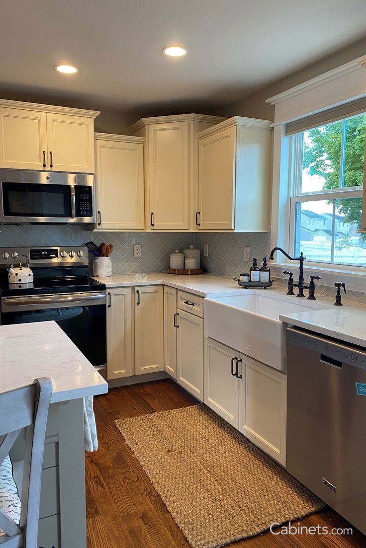 a kitchen with white cabinets and stainless steel appliances