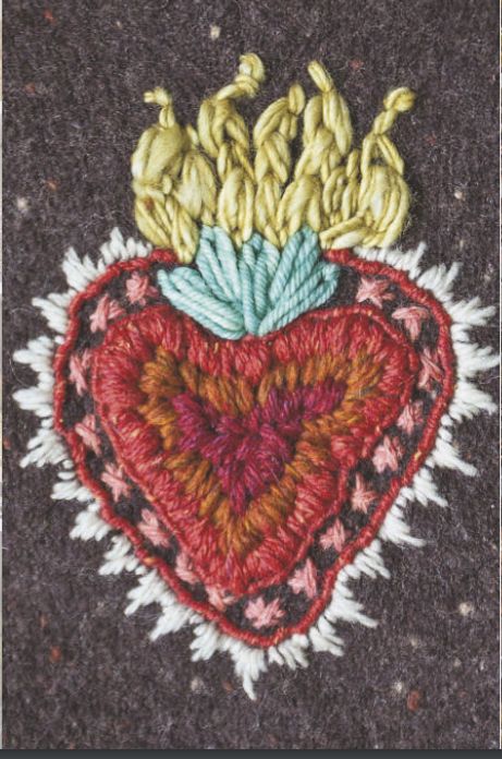 an embroidered heart with flowers in the middle