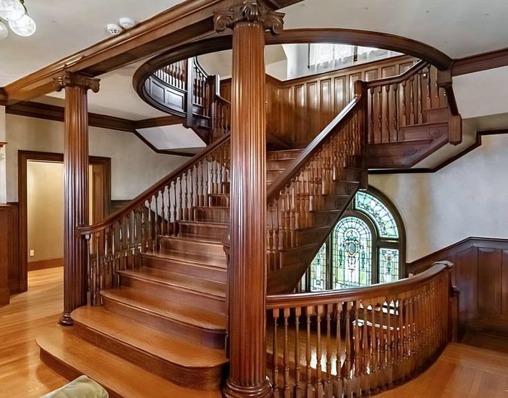 a large wooden staircase in a home with stained glass windows and wood trimmings