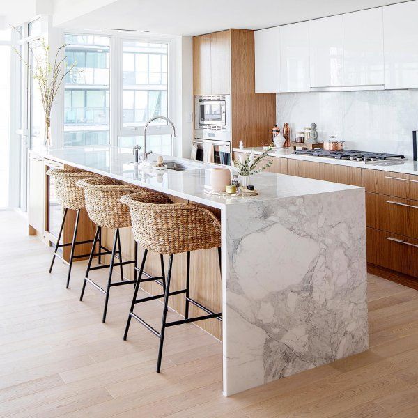 a kitchen with marble counter tops and bar stools in front of the island area