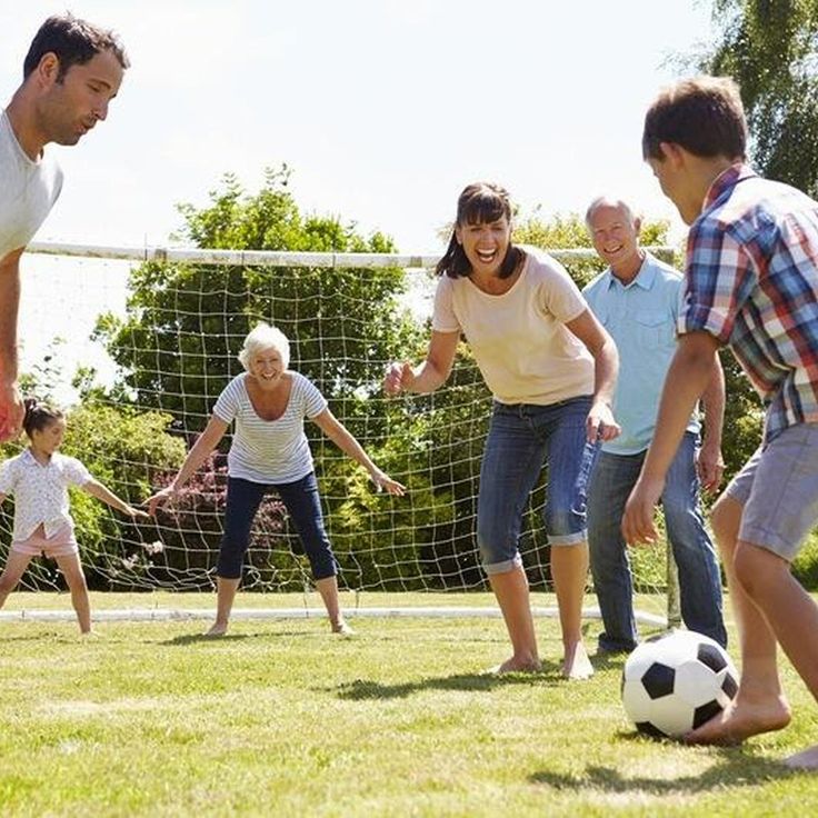 a group of people are playing soccer on the grass in front of a goalie net