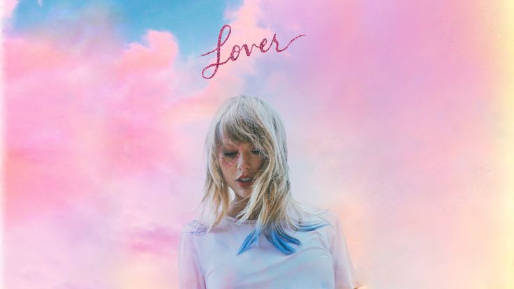 a woman standing in front of a pink and blue background with the word lover written on it