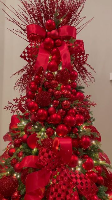 a christmas tree decorated with red ornaments and bows