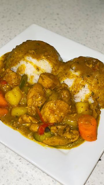 a white plate topped with meat and veggies covered in gravy on top of a table