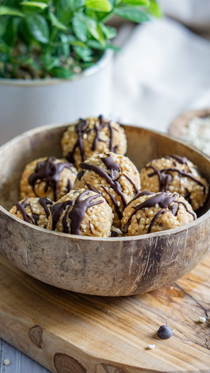 a wooden bowl filled with cookies covered in chocolate