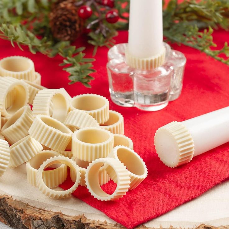 some kind of pasta sitting on top of a red napkin next to a white candle