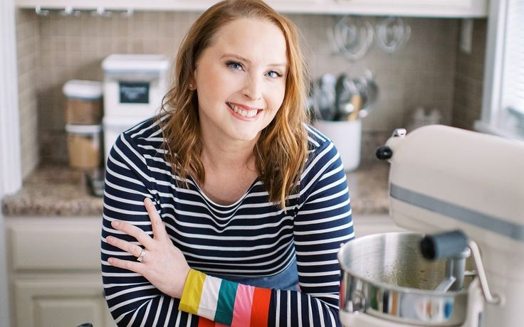 a woman is standing in the kitchen with her arms crossed