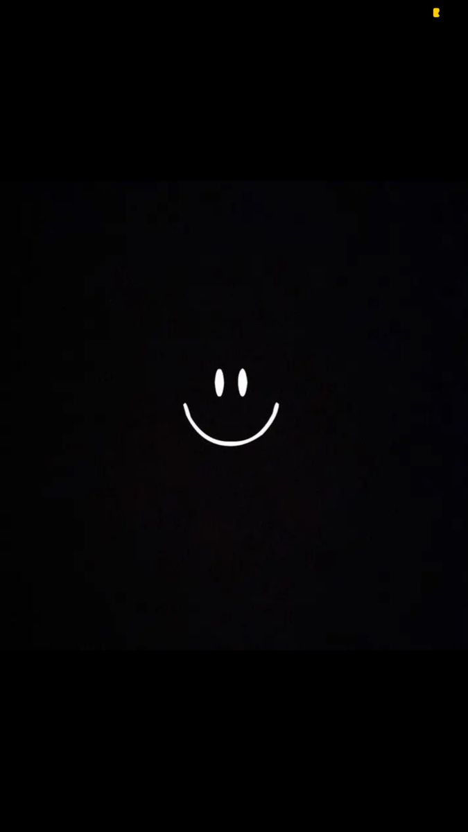 a black background with a smiley face drawn on it's side in the dark