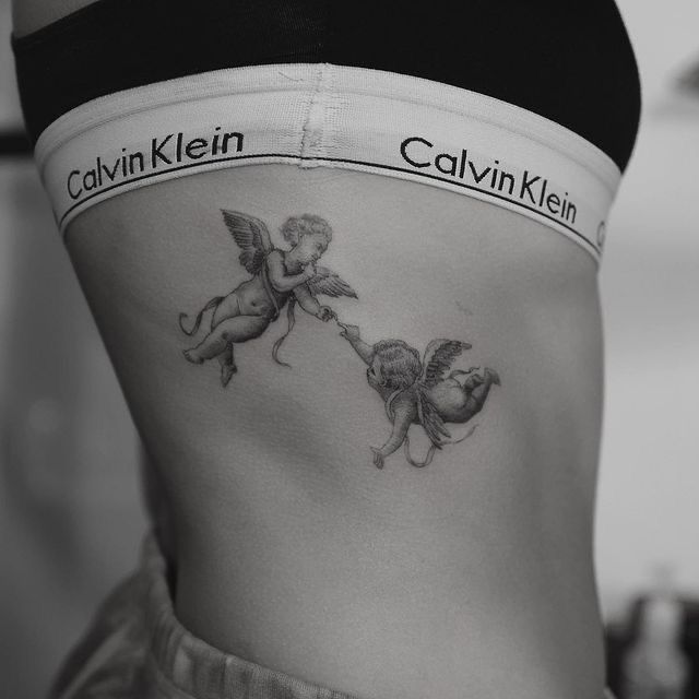 a woman's stomach with two cherubs on it and the words calvin klein written in black ink