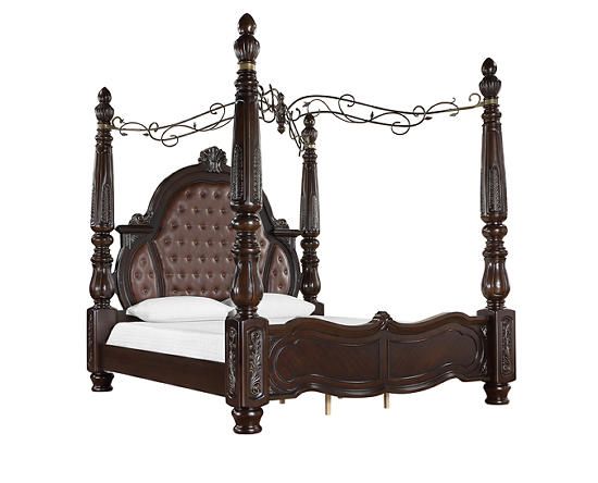 a bed with four posts and white sheets