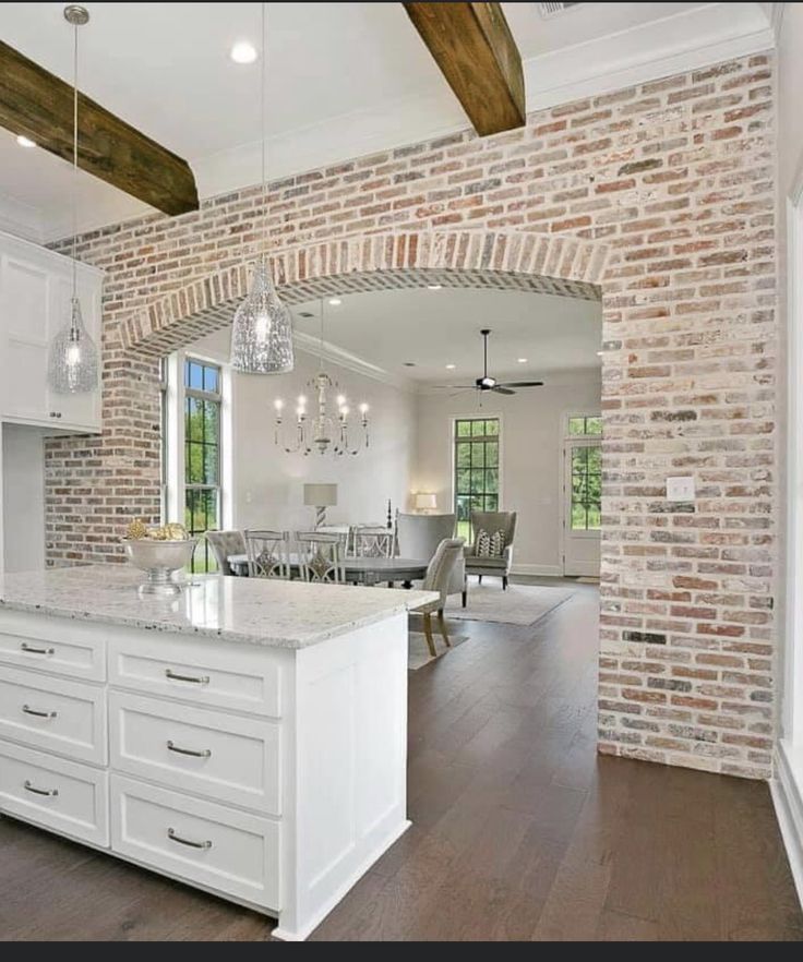 an open kitchen and dining room with brick walls