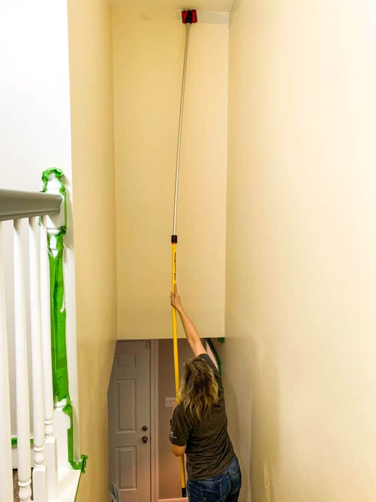 a man is cleaning the stairs with a mop and bucket in an apartment hallway