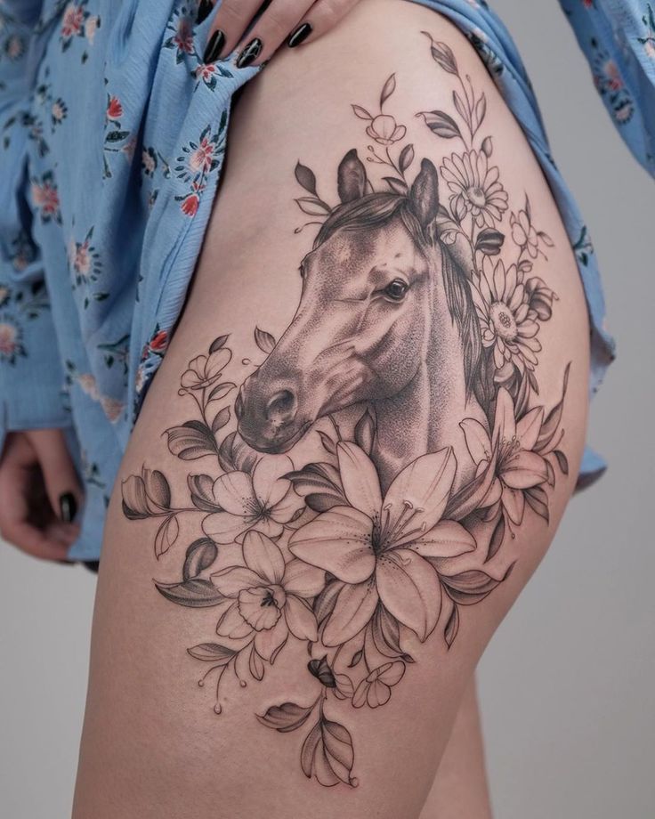 a woman's thigh with a horse and flowers on it